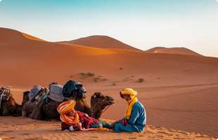 a camel guide sitting in the desert