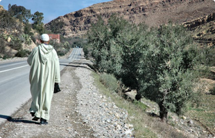 a elderly man walking on the side of street around Agadir